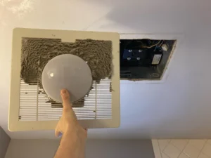 professional cleaner dusting air vent and ceiling fan in Maryland home