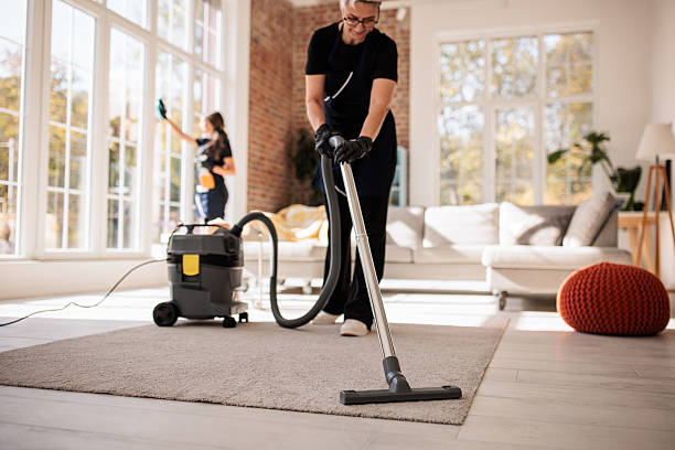 professional house cleaner vacuuming living room in Maryland home